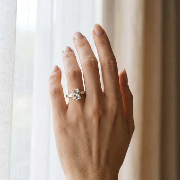 Yellow gold Emerald Cut Diamond Solitaire Ring with Tapered Baguette Accents and Four-Prong Setting