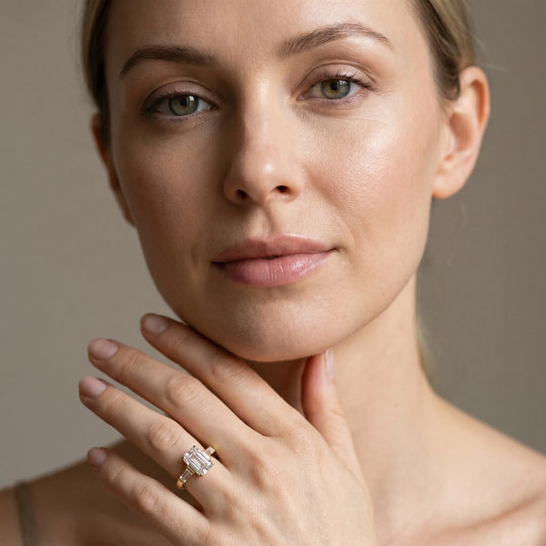 Yellow gold Emerald Cut Diamond Solitaire Ring with Tapered Baguette Accents and Four-Prong Setting