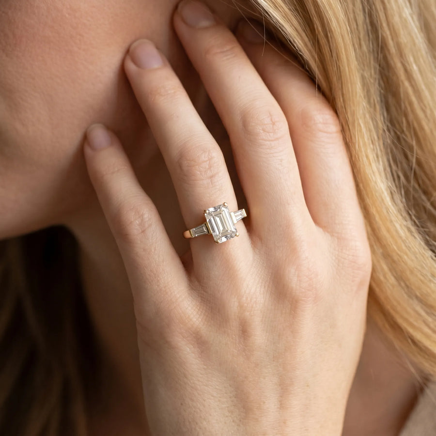 Yellow gold Emerald Cut Diamond Solitaire Ring with Tapered Baguette Accents and Four-Prong Setting