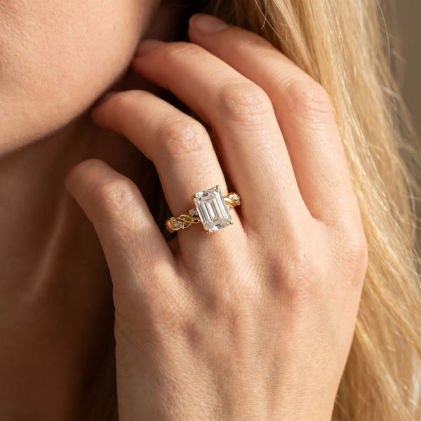 Yellow gold Emerald Cut Diamond Solitaire Ring with Twisted Band and Pavé Accents