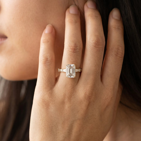 Yellow gold Emerald Cut Diamond Solitaire with Side Baguettes and Channel Set Band