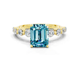 Yellow gold Emerald Cut Solitaire Blue Topaz Ring with Pave Band and Four-Prong Setting