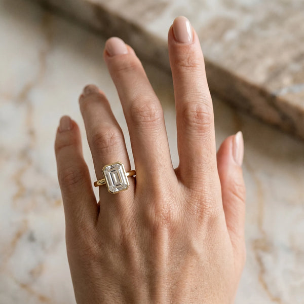 Yellow gold Emerald Cut Solitaire Ring with Four-Prong Setting and Classic Band