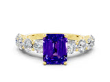 Yellow gold Emerald Cut Tanzanite Prong Setting with Side Stones on a Pave Band