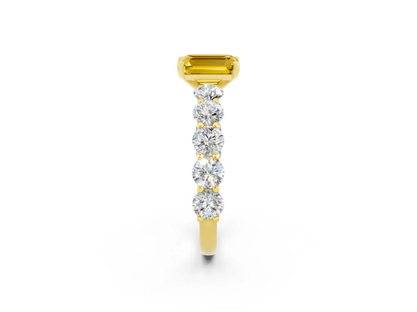Yellow gold Emerald Cut Yellow Sapphire Prong Setting with Side Stones on a Pave Band