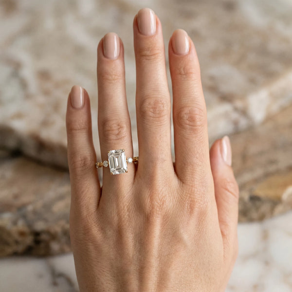 Yellow gold Emerald Solitaire Diamond Ring with Bezel Set Side Stones and Prong Setting