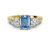 Yellow gold Fancy Blue Emerald Cut Three-Stone Diamond Ring with Pavé Band and Four-Prong Setting