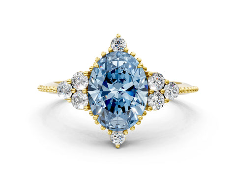 Yellow gold Fancy Blue Oval Cut Brilliant Diamond with Cluster Setting on a Beaded Band and Four-Prong Setting