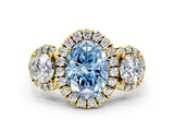 Yellow gold Fancy Blue Oval Cut Diamond Three-Stone Halo Ring with Prong Setting and Pavé Accents