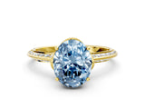 Yellow gold Fancy Blue Oval Cut Solitaire Split Shank Pave Diamond Engagement Ring with Four-Prong Setting