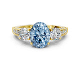 Yellow gold Fancy Blue Oval Cut Three-Stone Diamond Ring with Pavé Band and Four-Prong Setting