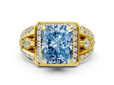 Yellow gold Fancy Blue Radiant Cut Diamond Halo Ring with Split Shank and Bezel Accents and Four-Prong Setting