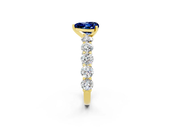 Yellow gold Heart Cut Blue Sapphire Prong Setting with Side Stones on a Pave Band