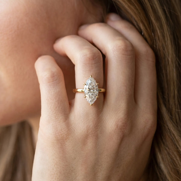 Yellow gold Marquise Solitaire Diamond Engagement Ring with Four-Prong Setting on a Classic Band