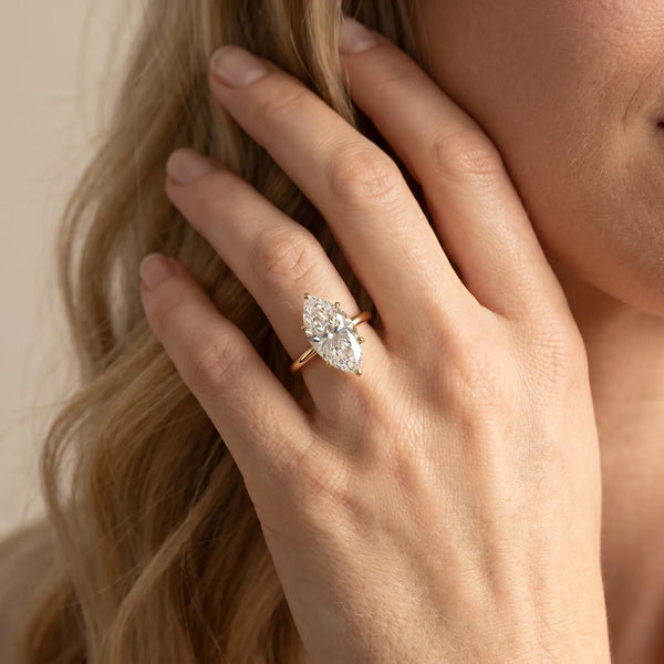 Yellow gold Marquise Solitaire Diamond Ring with Four-Prong Setting on a Plain Band