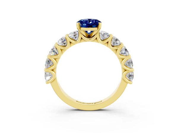 Yellow gold Oval Cut Blue Sapphire Prong Setting with Side Stones on a Pave Band