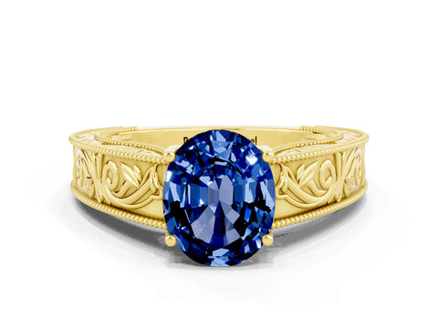 Yellow gold Oval Cut Blue Sapphire Solitaire Ring with Engraved Band and Four-Prong Setting