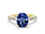 Yellow gold Oval Cut Blue Sapphire Solitaire with Side Baguettes and Channel Set Band