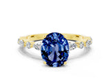 Yellow gold Oval Cut Blue Sapphire Solitaire with Side Stones on a Pavé Band and Four-Prong Setting