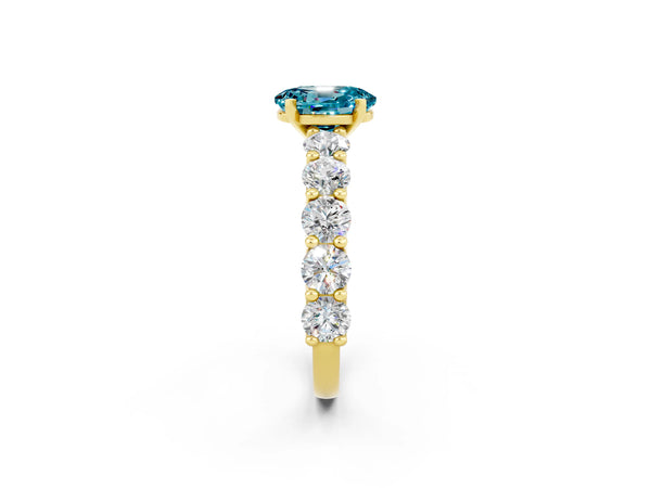 Yellow gold Oval Cut Blue Topaz Prong Setting with Side Stones on a Pave Band
