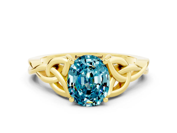 Yellow gold Oval Cut Blue Topaz Solitaire Engagement Ring with Celtic Knot Band and Four-Prong Setting