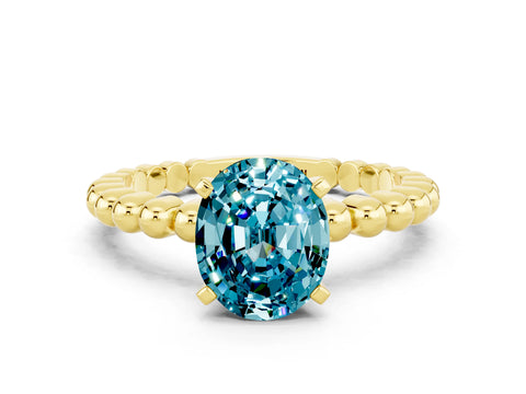 Yellow gold Oval Cut Blue Topaz Solitaire Ring with Beaded Band and Prong Setting