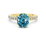 Yellow gold Oval Cut Blue Topaz Solitaire Ring with Pavé Accents and Four-Prong Setting