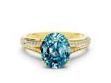 Yellow gold Oval Cut Blue Topaz Split Shank Engagement Ring with Pavé Band