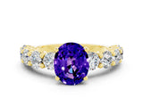 Yellow gold Oval Cut Tanzanite Prong Setting with Side Stones on a Pave Band