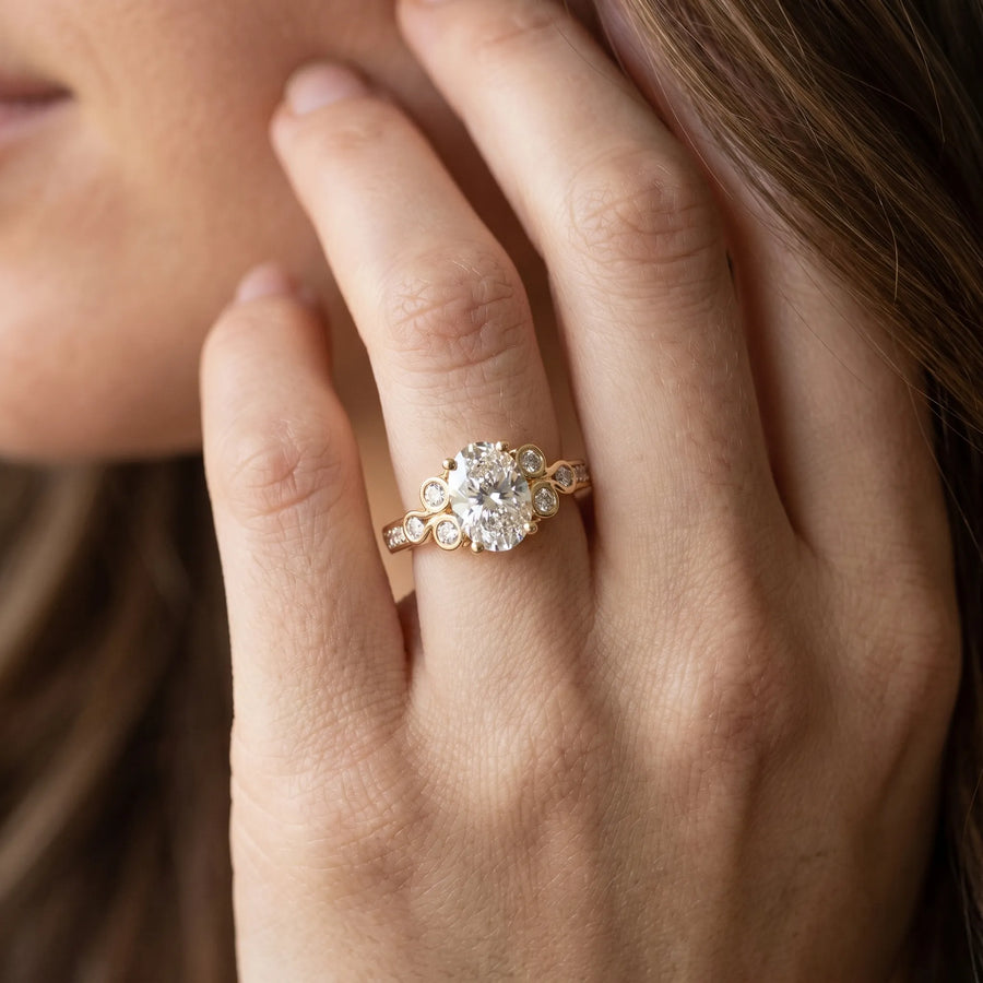Yellow gold Oval Diamond Bezel and Prong Setting with Pave Band
