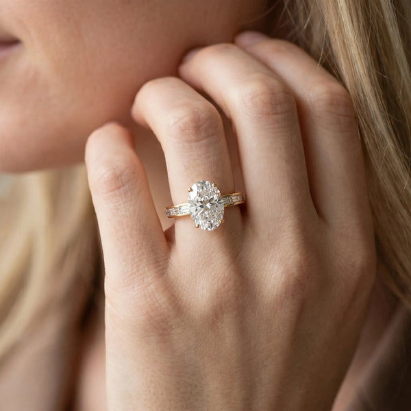 Yellow gold Oval Solitaire Diamond Ring with Channel-Set Baguette Band and Four-Prong Setting