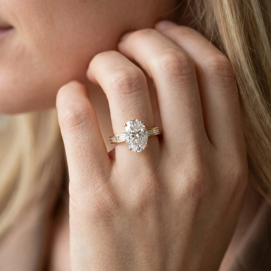 Yellow gold Oval Solitaire Diamond Ring with Channel-Set Baguette Band and Four-Prong Setting