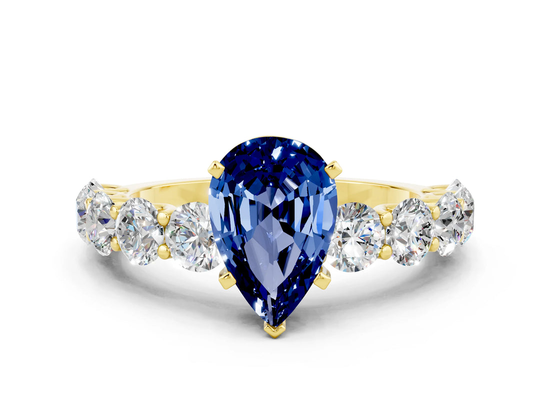 Yellow gold Pear Cut Blue Sapphire Prong Setting with Side Stones on a Pave Band