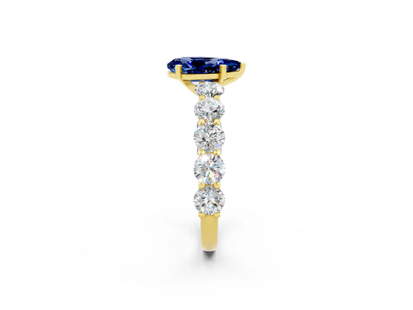 Yellow gold Pear Cut Blue Sapphire Prong Setting with Side Stones on a Pave Band