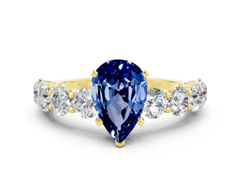 Yellow gold Pear Cut Blue Sapphire Prong Setting with Side Stones on a Pave Band