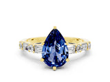 Yellow gold Pear Cut Blue Sapphire Solitaire with Side Baguettes and Channel Set Band