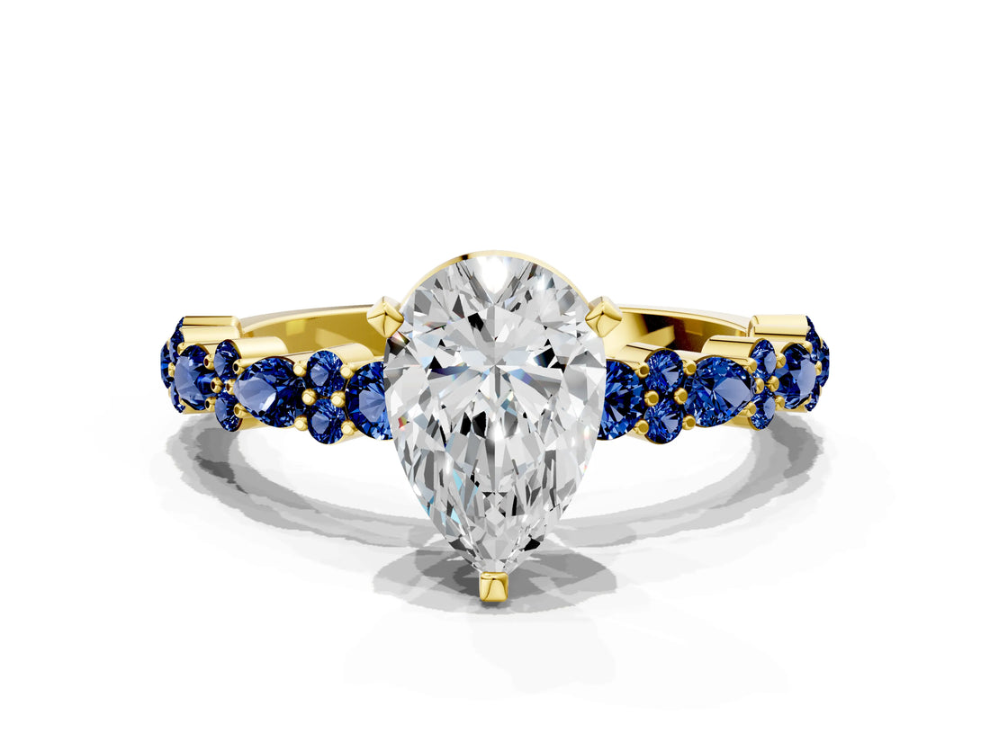 Yellow gold Pear Cut Diamond Side Stone Solitaire Ring with Round with Blue Sapphire side stone and Four-Prong Setting