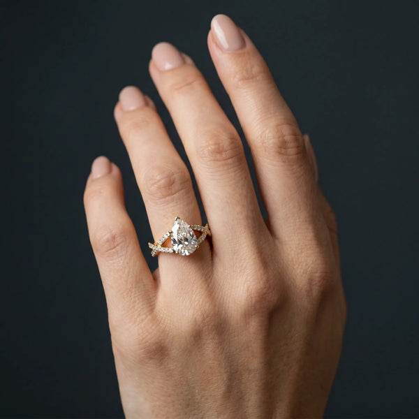 Yellow gold Pear Cut Diamond Solitaire Ring with Four-Prong Setting and Twisted Pavé Band