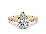 Yellow gold Pear Cut Moissanite Solitaire with Side Baguettes and Channel Set Band