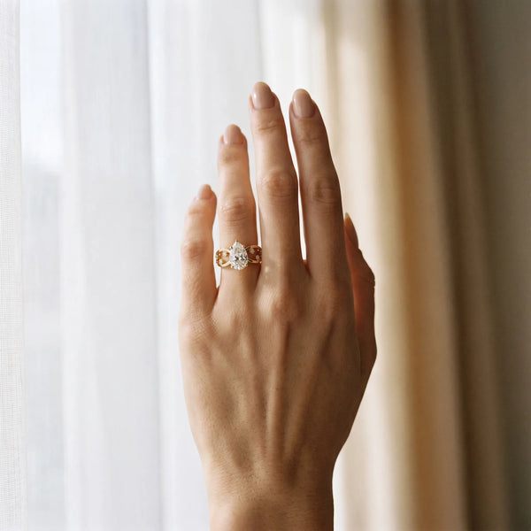 Yellow gold Pear Cut Solitaire Diamond with Side Stones on Criss-Cross Band and Four-Prong Setting