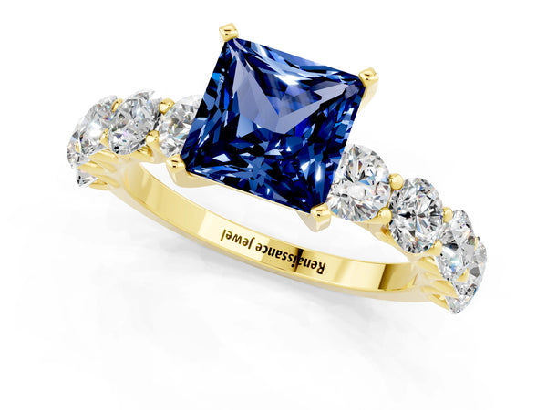 Yellow gold Princess Cut Blue Sapphire Prong Setting with Side Stones on a Pave Band