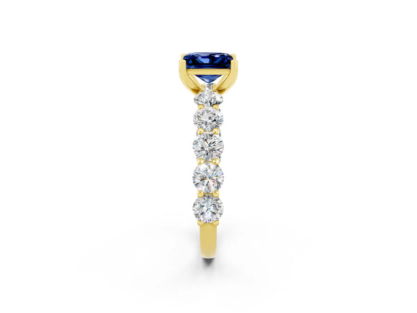 Yellow gold Princess Cut Blue Sapphire Prong Setting with Side Stones on a Pave Band