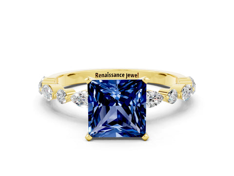 Yellow gold Princess Cut Blue Sapphire Solitaire with Side Stones on a Pavé Band and Four-Prong Setting