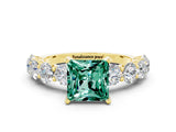 Yellow gold Princess Cut Green Sapphire Prong Setting with Side Stones on a Pave Band