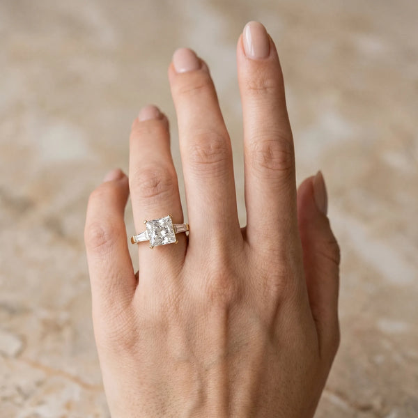 Yellow gold Princess Solitaire with Tapered Baguette Side Stones on a Classic Band with Four-Prong Setting