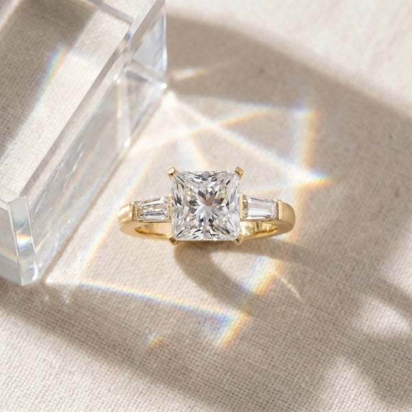 Yellow gold Princess Solitaire with Tapered Baguette Side Stones on a Classic Band with Four-Prong Setting