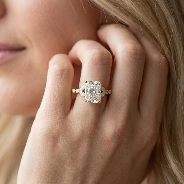 Yellow gold Radiant Cut Diamond Solitaire Ring with Side Stones and Four-Prong Setting