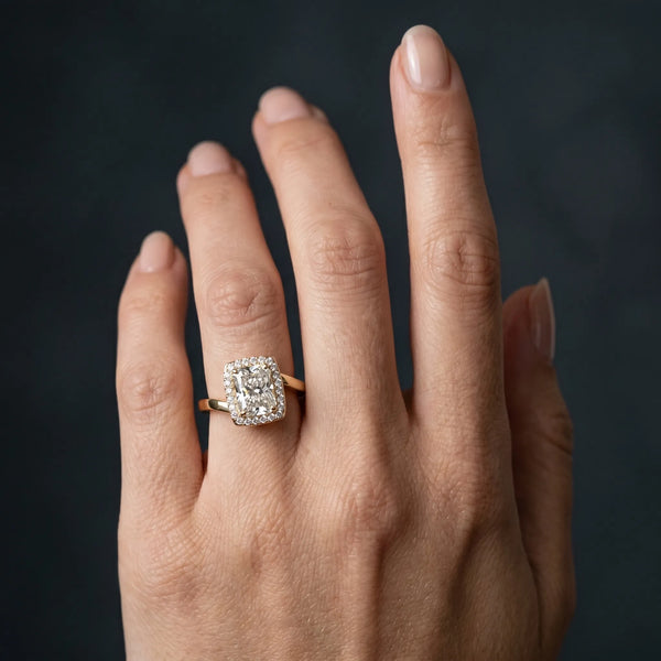 Yellow gold Radiant Cut Halo Solitaire Ring with Channel Band and Four-Prong Setting