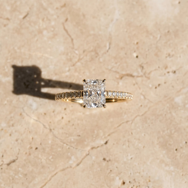 Yellow gold Radiant Cut Solitaire Diamond Ring with Pave Band and Four-Prong Setting