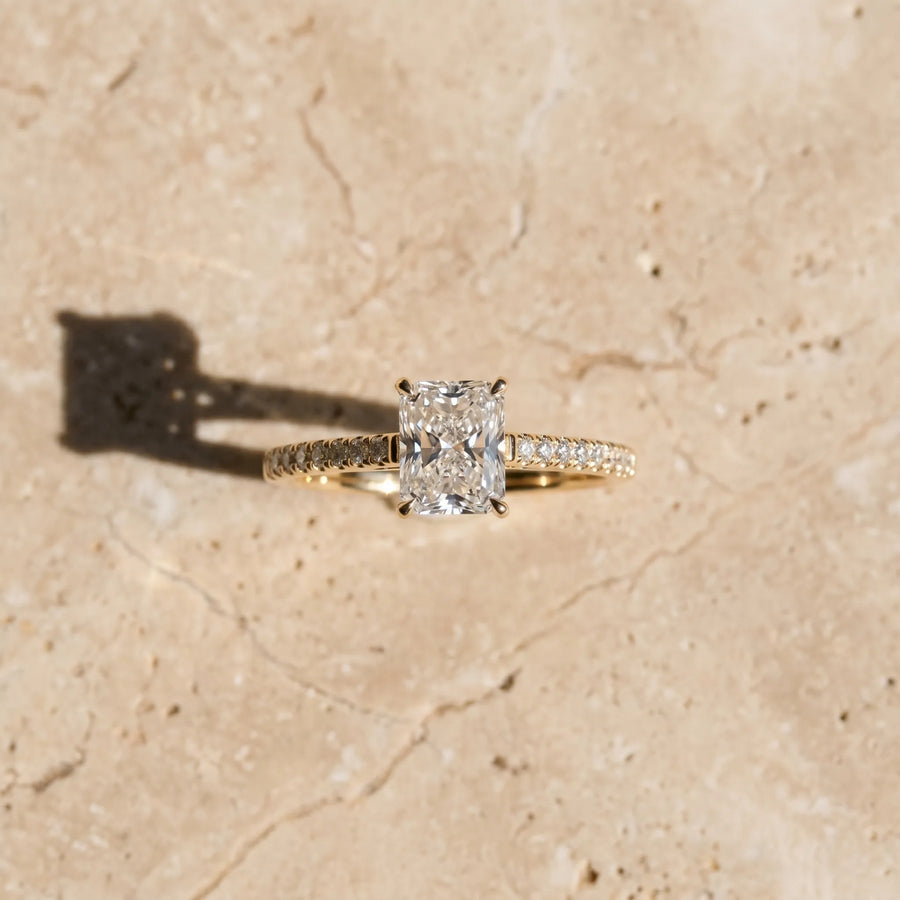 Yellow gold Radiant Cut Solitaire Diamond Ring with Pave Band and Four-Prong Setting